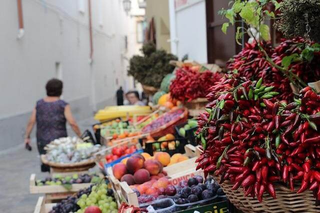 Marktstand mit Früchten, Peperoni, Gemüse 